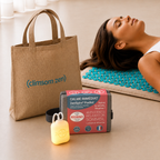 Le sac de transport Climsom Zen, la boîte du ZenSpire Pocket et le ZenSpire Pocket allumé, devant une femme allongée sur le tapis d’acupression
