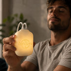 Homme les yeux fermés qui tient un ZenSpire Pocket allumé en jaune doux