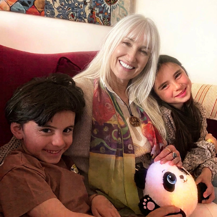 Une grand-mère et deux enfants autour de la peluche Zen’A allumée